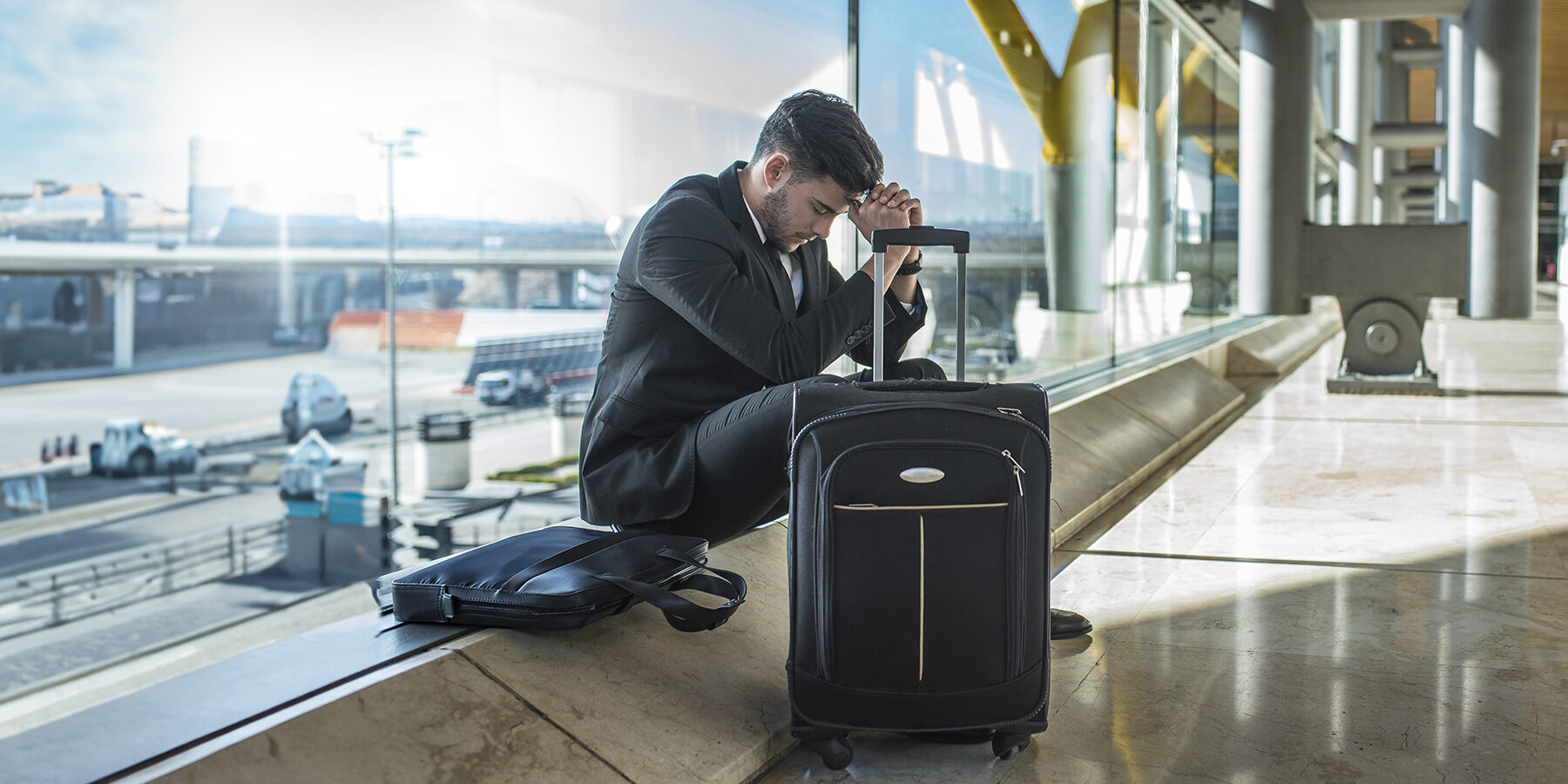 Pessoa sentada em um aeroporto, aparentando cansaço devido ao jet lag após uma longa viagem
